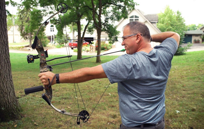 Man practicing with a compound bow